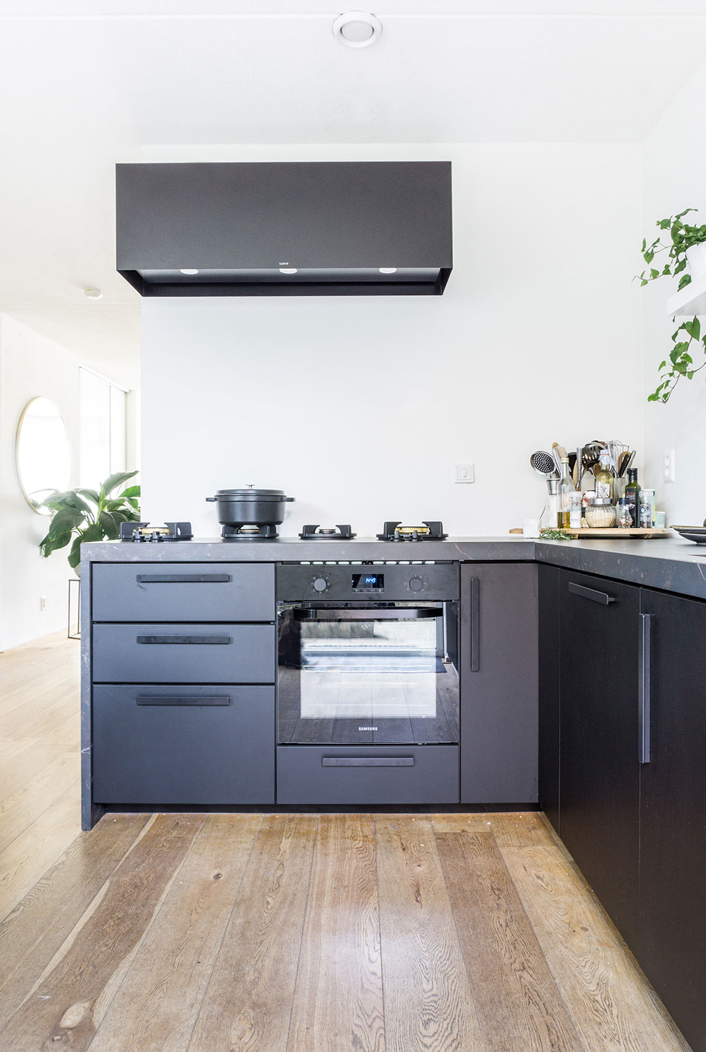 Zwarte keuken met dekton aanrechtblad en houten vloer | Stek Magazine