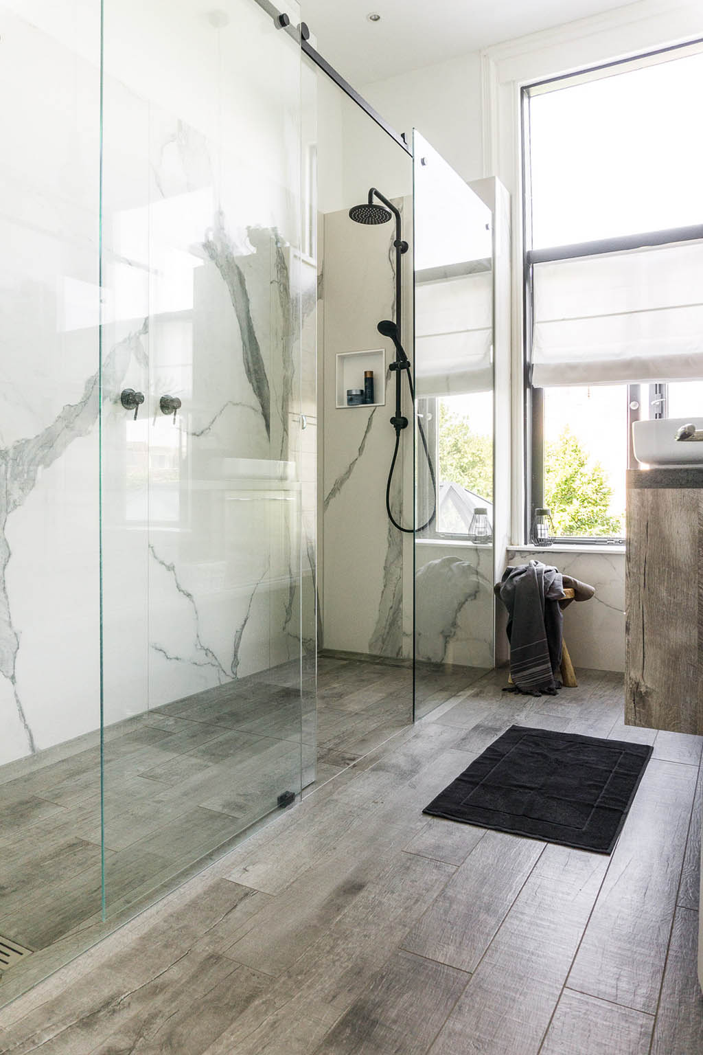 Houten kunststof vloer badkamer marmer tegels zwarte douche | Stek Magazine