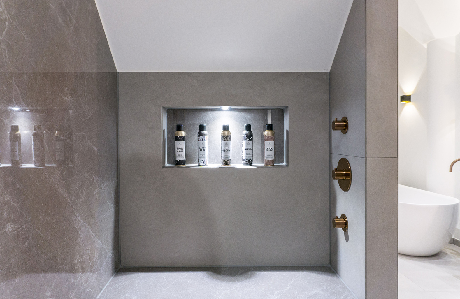 Moderne badkamer met koperen kranen en douche, wit ovaal losstaand bad | Stek Magazine