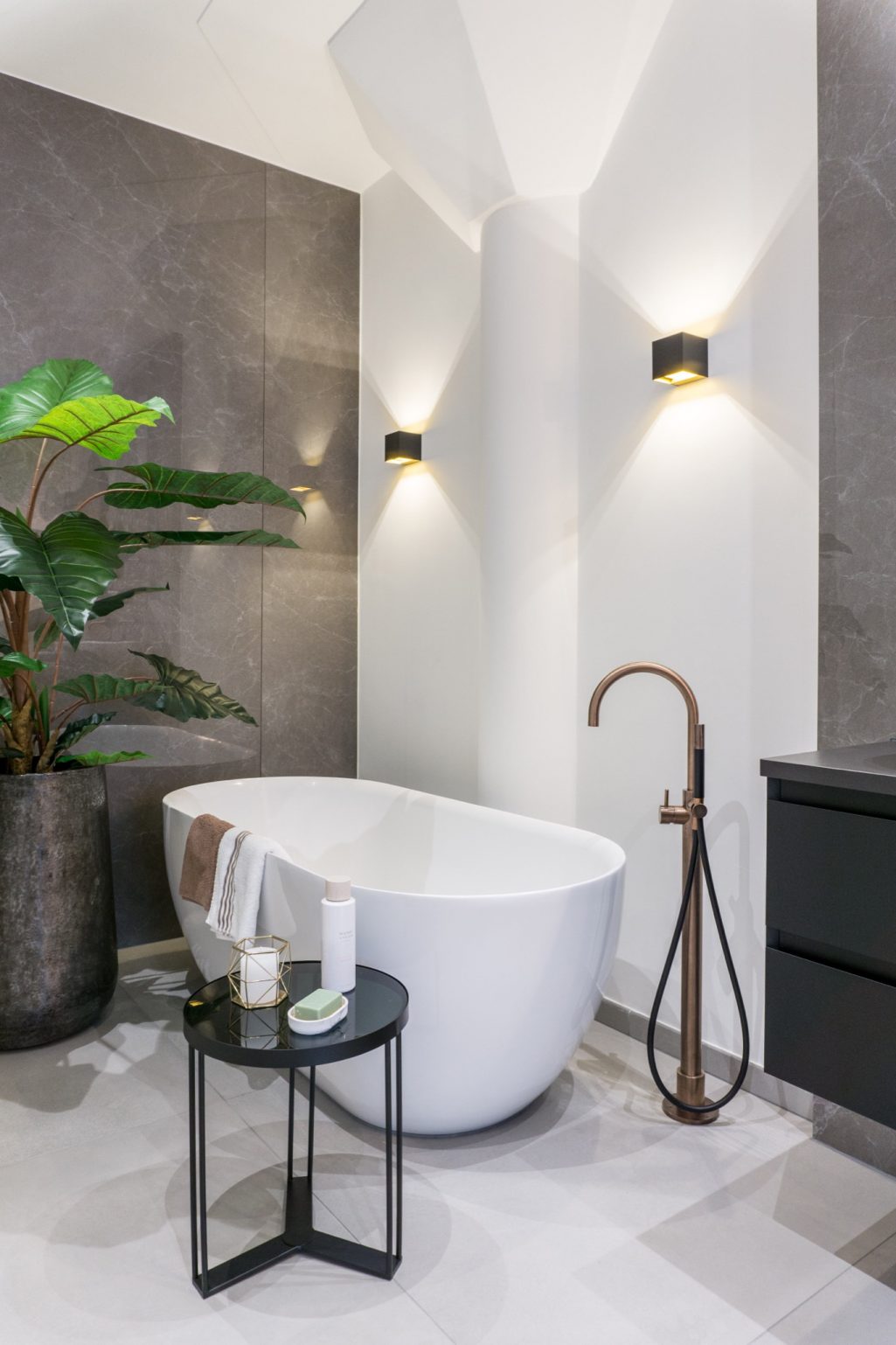 Badkamer met ovaal vrijstaand bad en gouden kranen | Stek Woonmagazine