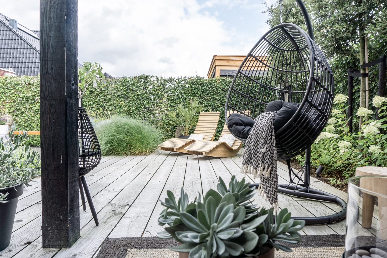 Zwarte rieten hangstoel tuin | Stek Magazine